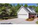 Well-maintained home with a two-car garage, framed by manicured landscaping and lush trees at 866 Lee Byrd Rd, Loganville, GA 30052