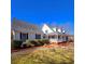 Charming white home with black shutters, a welcoming front porch, and beautifully maintained landscaping at 866 Lee Byrd Rd, Loganville, GA 30052