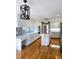 Beautiful kitchen with wooden floors, white cabinets, stainless steel appliances, and a decorative wrought iron chandelier at 866 Lee Byrd Rd, Loganville, GA 30052