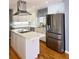 Bright kitchen with stainless steel fridge, island cooktop, white cabinets and updated sink and fixtures at 866 Lee Byrd Rd, Loganville, GA 30052