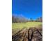Scenic land with grass and trees, enhanced by overhead electric lines and a bright blue sky at 866 Lee Byrd Rd, Loganville, GA 30052