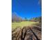 A peaceful meadow landscape with green grass and trees, under a blue sky with overhead electric lines at 866 Lee Byrd Rd, Loganville, GA 30052