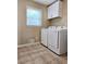 Bright laundry room features tile floors, cabinets and newer washer and dryer at 866 Lee Byrd Rd, Loganville, GA 30052