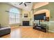 Bright living room featuring hardwood floors, fireplace, large window, and modern ceiling fan at 1342 Orchard Park Dr, Stone Mountain, GA 30083