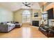 Comfortable living room featuring hardwood floors, fireplace, large window, and gray sectional sofa at 1342 Orchard Park Dr, Stone Mountain, GA 30083