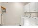 Bright laundry room with white washer, dryer, and upper cabinets at 2203 Fullers Aly, Kennesaw, GA 30144