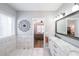 This bright bathroom features marble tile floors, white cabinetry, and a view into the bedroom at 3831 Portland Trail Dr, Suwanee, GA 30024