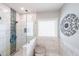 Bright bathroom featuring a glass-enclosed shower with decorative tile and marble tile walls at 3831 Portland Trail Dr, Suwanee, GA 30024