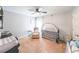 Neutral bedroom with fan, side table, crib, and white door at 3831 Portland Trail Dr, Suwanee, GA 30024