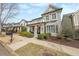 Charming gray home with a front porch, white columns, a second story balcony, and manicured landscaping at 3831 Portland Trail Dr, Suwanee, GA 30024