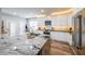 Stylish kitchen featuring a large island with granite countertops, stainless steel appliances and wooden floors at 3831 Portland Trail Dr, Suwanee, GA 30024