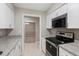 Galley kitchen featuring white cabinets, granite countertops, and stainless steel appliances at 25213 Plantation Ne Dr # 25213, Atlanta, GA 30324
