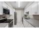 Modern kitchen with white cabinets, granite countertops, and stainless steel appliances at 25213 Plantation Ne Dr # 25213, Atlanta, GA 30324