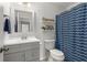 Well-lit bathroom with updated vanity, wainscotting, and a shower with a blue patterned curtain at 244 Hiawassee Dr, Woodstock, GA 30188