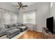 Comfortable living room with hardwood floors, lots of windows, and a gray sectional sofa at 244 Hiawassee Dr, Woodstock, GA 30188