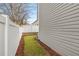 A narrow side yard with green grass between the house and a white fence at 244 Hiawassee Dr, Woodstock, GA 30188