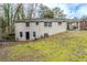 Back view of home featuring brick facade, black door, grassy hill, and covered porch at 2096 Snow Sw Rd, Atlanta, GA 30311