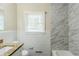 This bathroom features granite countertops, marble accent walls, and white tiling at 2096 Snow Sw Rd, Atlanta, GA 30311