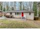 Charming single-story home featuring a brick facade and a vibrant red front door at 2096 Snow Sw Rd, Atlanta, GA 30311