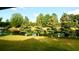 Serene backyard view of a pond with lush green trees and grass at 300 Jonesboro Rd, Mcdonough, GA 30253