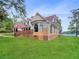 House exterior showcasing a red roof, brick accents, and a spacious lawn at 300 Jonesboro Rd, Mcdonough, GA 30253