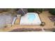 Aerial view of a community pool featuring a unique shape, surrounded by a fence, parking, and greenery at 4335 Silent Path, Cumming, GA 30028