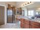 Large bathroom with dual sinks, wooden cabinets, a glass shower and tub at 4335 Silent Path, Cumming, GA 30028