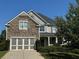 Charming two-story home with a stone facade, gray siding, two-car garage, and well-maintained landscaping at 4335 Silent Path, Cumming, GA 30028
