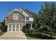 Two-story home with stone and siding accents, three-car garage, and landscaped yard at 4335 Silent Path, Cumming, GA 30028