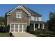 Two-story home with stone and siding accents, three-car garage, and landscaped yard at 4335 Silent Path, Cumming, GA 30028