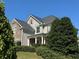Two-story home with stone and siding accents, three-car garage, and landscaped yard at 4335 Silent Path, Cumming, GA 30028