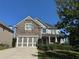 Two-story home with stone and siding accents, three-car garage, and landscaped yard at 4335 Silent Path, Cumming, GA 30028