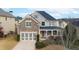 Attractive two-story home boasting a stone facade, gray siding, a two-car garage, and mature landscaping at 4335 Silent Path, Cumming, GA 30028