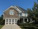 Beautiful two-story home with a stone facade, gray siding, a two-car garage, and manicured landscaping at 4335 Silent Path, Cumming, GA 30028