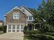 Attractive two-story home boasting a stone facade, gray siding, a two-car garage, and mature landscaping at 4335 Silent Path, Cumming, GA 30028