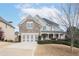Front exterior view of home featuring a stone facade, 2-car garage, and manicured lawn at 4335 Silent Path, Cumming, GA 30028