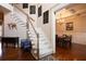 Elegant foyer showcasing hardwood floors, a staircase, and a dining room with a chandelier at 4335 Silent Path, Cumming, GA 30028