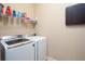 Convenient laundry room with modern washer and dryer, plus storage shelving for organization at 4335 Silent Path, Cumming, GA 30028