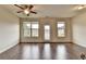 Bright living room with hardwood floors, ceiling fan, and a glass door leading outside at 5831 Taka Ln, Lithonia, GA 30038