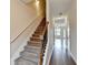 Carpeted staircase with wooden railing leads to the upper level of the home at 5831 Taka Ln, Lithonia, GA 30038