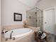 Bathroom showcasing a soaking tub and glass shower with decorative tile accents at 201 Russell Ct, Canton, GA 30115