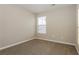 A cozy bedroom featuring neutral paint, plush carpeting, and a window with bright, natural light at 2229 Bigwood Trl, Atlanta, GA 30349