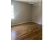 Neutral bedroom with hardwood flooring and natural light from a large window at 7205 Lakeview Dr, Covington, GA 30014