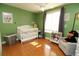 Bright Bedroom with green walls, white crib, hardwood floors, and ample natural light at 850 Waterbrook Ct, Roswell, GA 30076