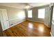 A bright bedroom featuring hardwood floors, two windows, and chair rail at 1600 Whisperwood Trl, Stone Mountain, GA 30088