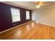 Large bedroom with hardwood floors, two windows, and a ceiling fan at 1600 Whisperwood Trl, Stone Mountain, GA 30088