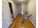 Hallway with hardwood floors that leads to a staircase and a bathroom at 1600 Whisperwood Trl, Stone Mountain, GA 30088