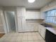 Bright kitchen with white cabinets, tile floor, and stainless steel sink at 1600 Whisperwood Trl, Stone Mountain, GA 30088