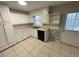 Kitchen featuring white cabinets, tile floor, and a stainless steel sink at 1600 Whisperwood Trl, Stone Mountain, GA 30088