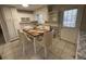 Cozy eat-in kitchen with white cabinets, stainless sink, and dining table set for six at 1600 Whisperwood Trl, Stone Mountain, GA 30088